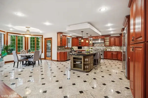 a kitchen with stainless steel appliances kitchen island granite countertop a sink and cabinets