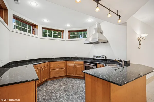 a kitchen with stainless steel appliances granite countertop a sink a stove and a refrigerator