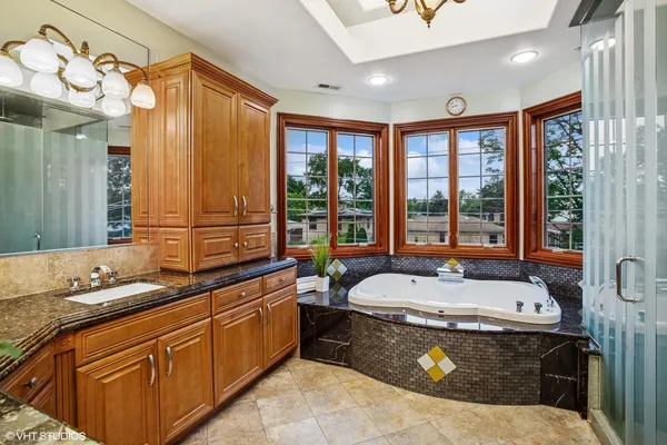 a spacious bathroom with a granite countertop tub and a sink