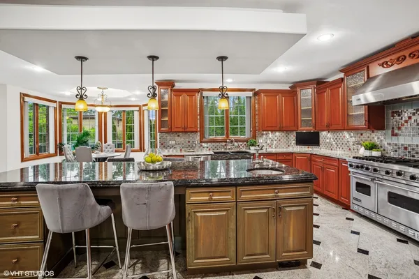 a kitchen with stainless steel appliances granite countertop a stove a sink dishwasher and cabinets with wooden floor