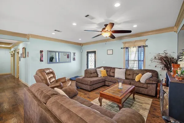 a living room with furniture kitchen view and a window
