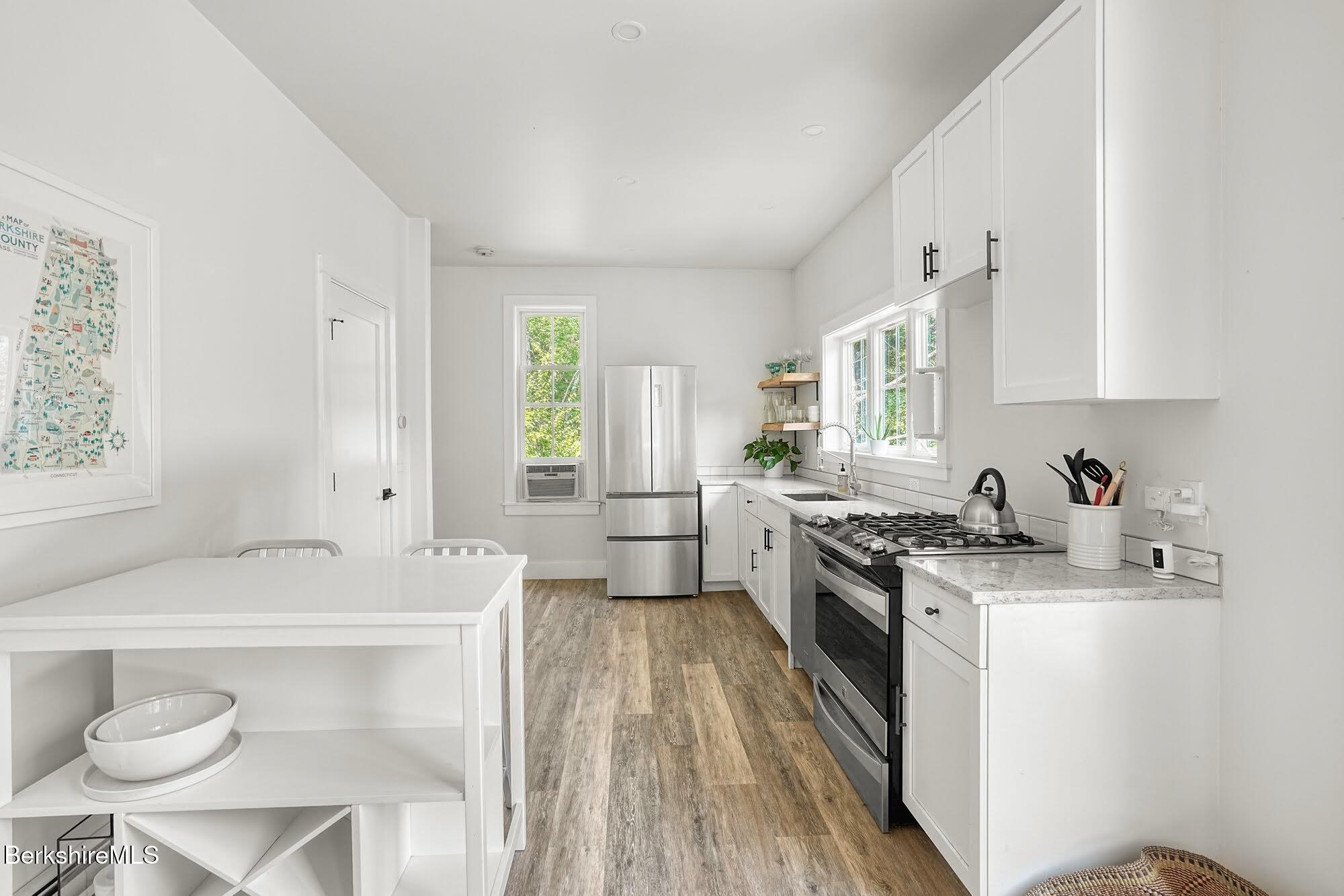 140 Beaver Dam Road Lee, MA 01238 - Photo 14 of 29 a kitchen with a sink a stove a refrigerator cabinets and a window