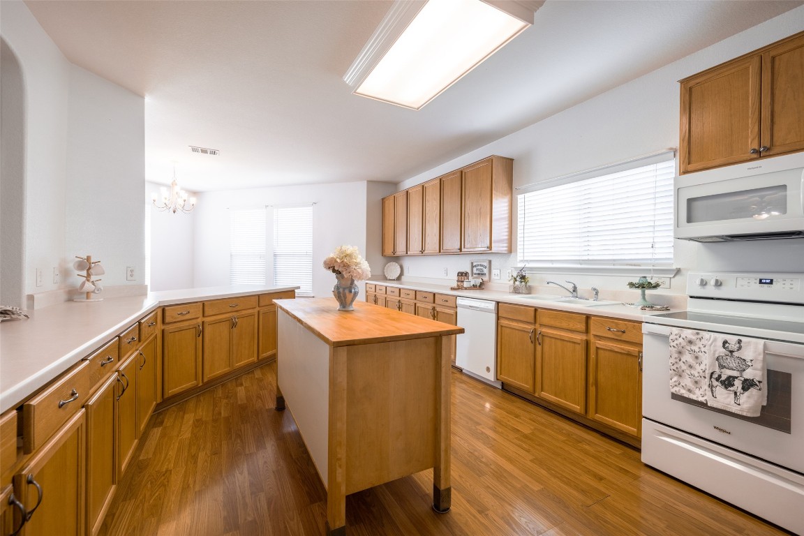 a large kitchen with a lot of counter space and wooden floor