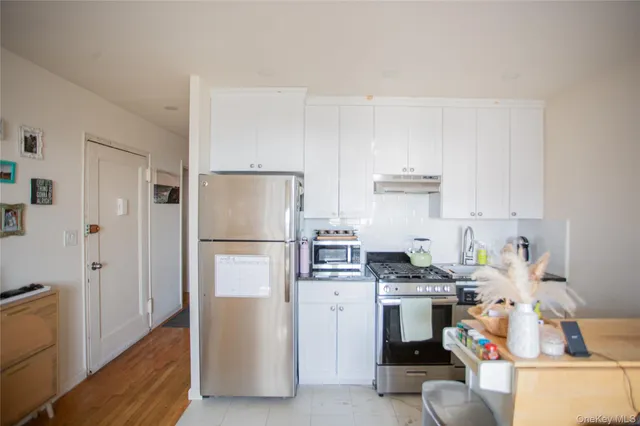 a kitchen with stainless steel appliances granite countertop a refrigerator stove and sink