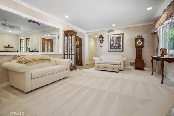 a living room with furniture a fireplace and a floor to ceiling window