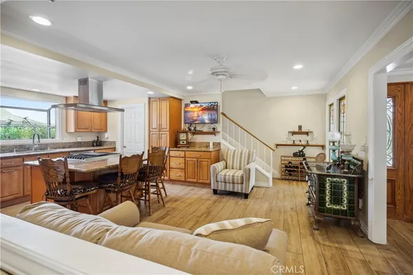 a living room with furniture kitchen view and a large window