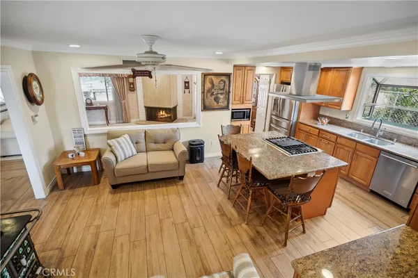 a kitchen with stainless steel appliances granite countertop a sink a stove and a wooden floors