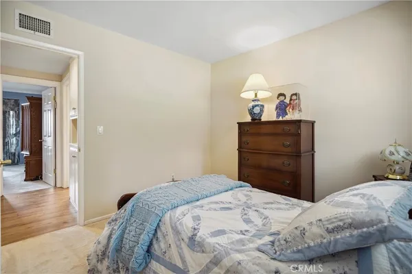 a bedroom with a bed mirror and a window