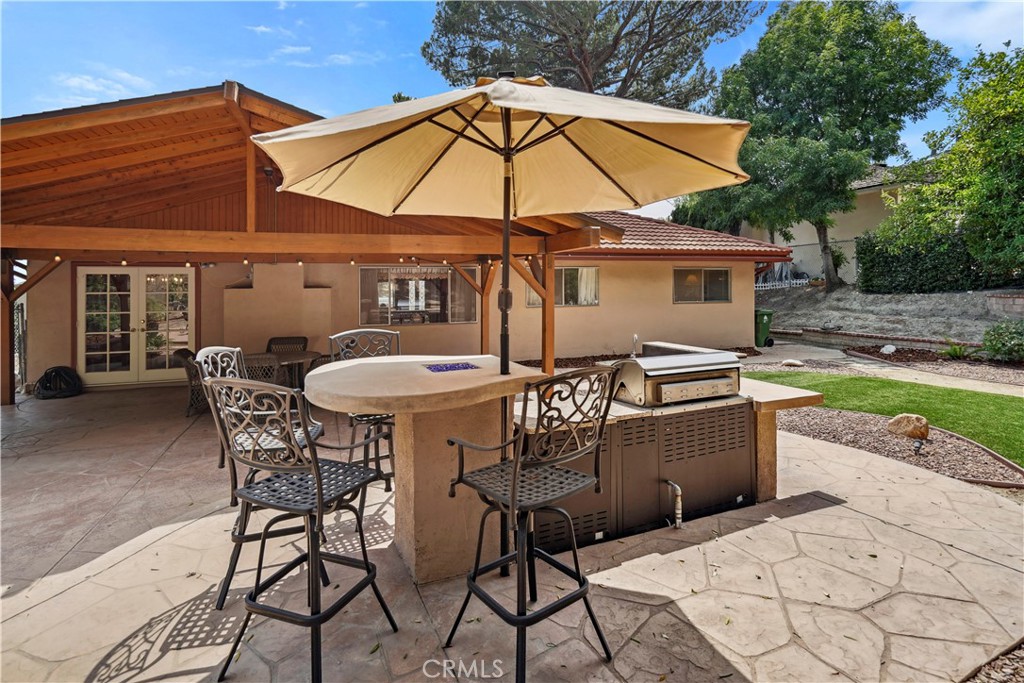 11300 Dulcet Avenue Porter Ranch, CA 91326 - Photo 53 of 55 a patio with a table and chairs under an umbrella