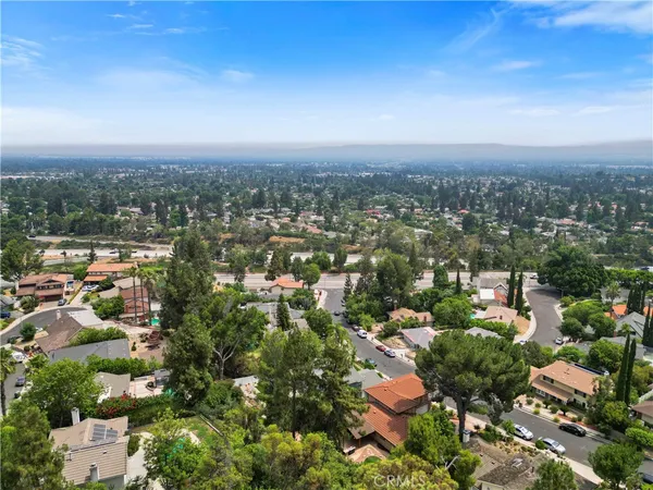 an aerial view of a house with a swimming pool and large trees