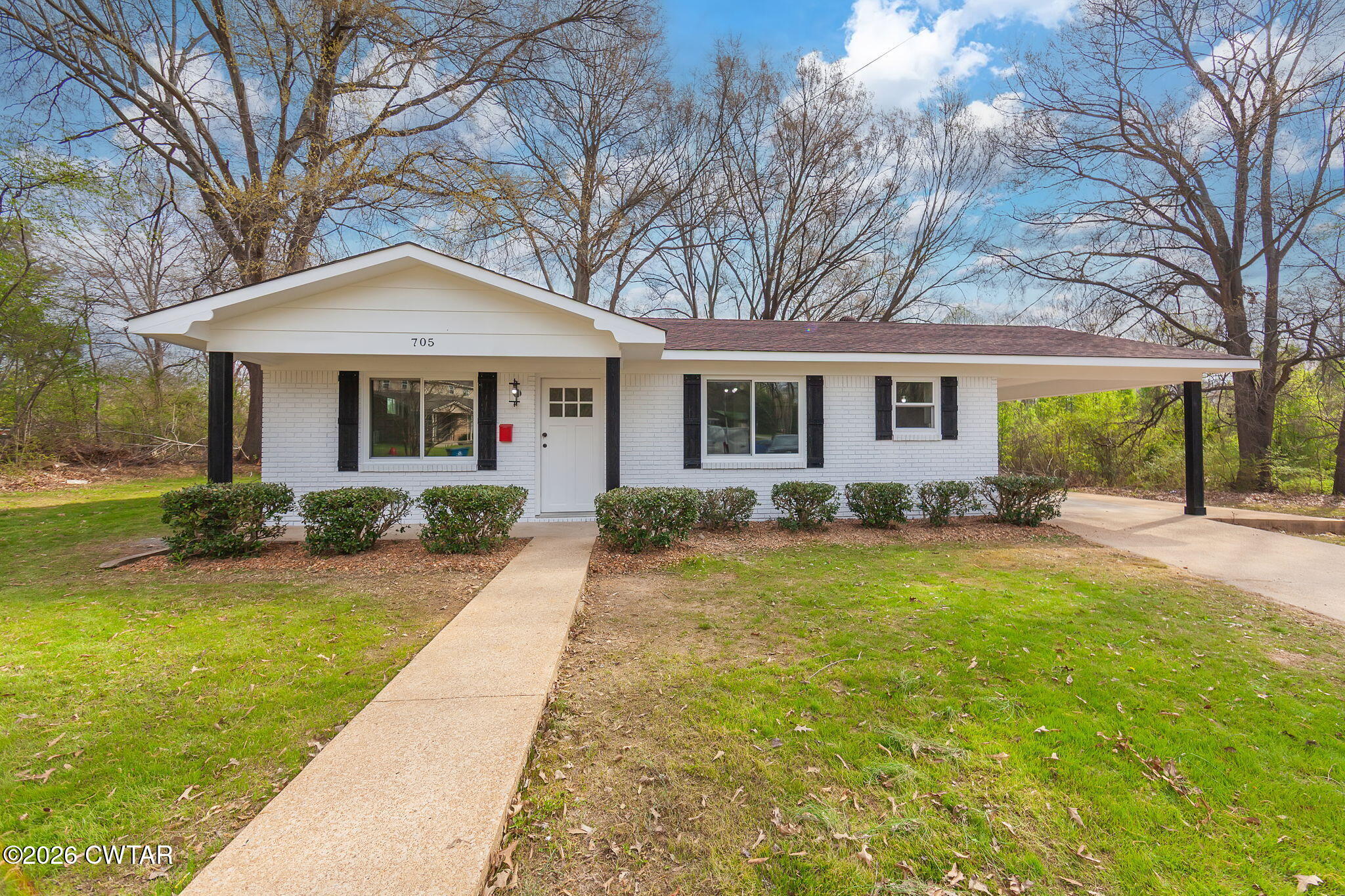 a front view of a house with yard patio and green space