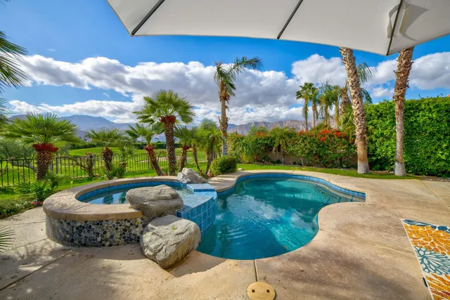 a backyard of a house with table and chairs plants and large trees