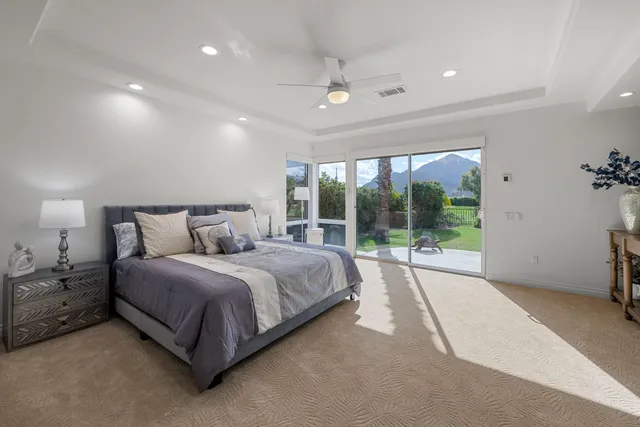 a spacious bedroom with a bed lamp and window