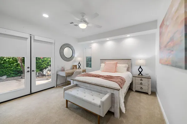 a bed room with a bed mirror and a chandelier