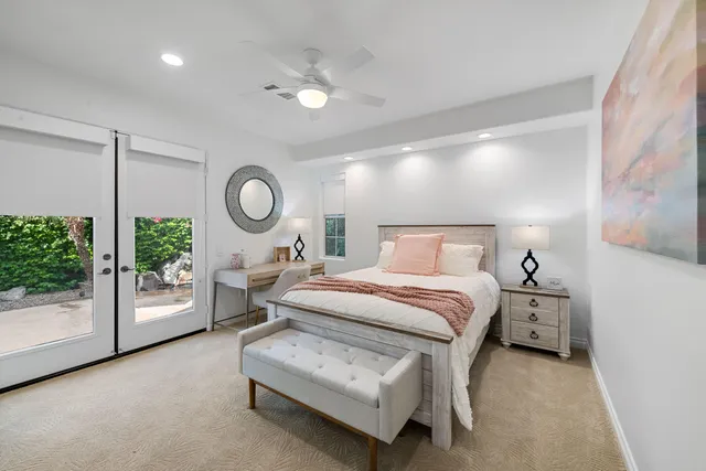 a bed room with a bed mirror and a chandelier