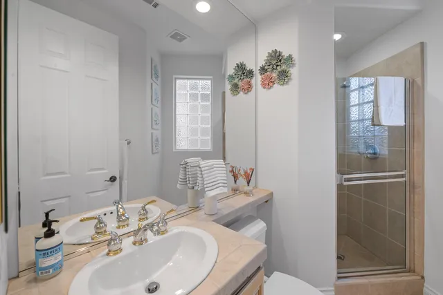 a bathroom with a sink a toilet and shower