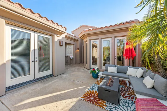 a view of a patio with couches table and chairs and potted plants