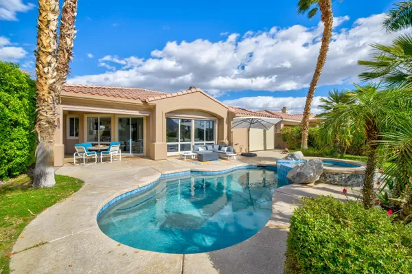 a view of a house with swimming pool and sitting area