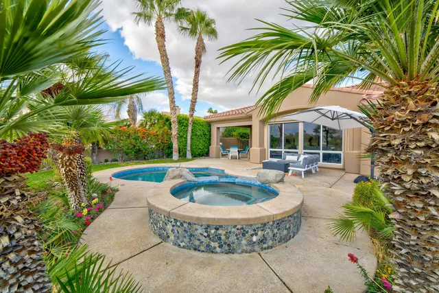 a view of a house with swimming pool and sitting area