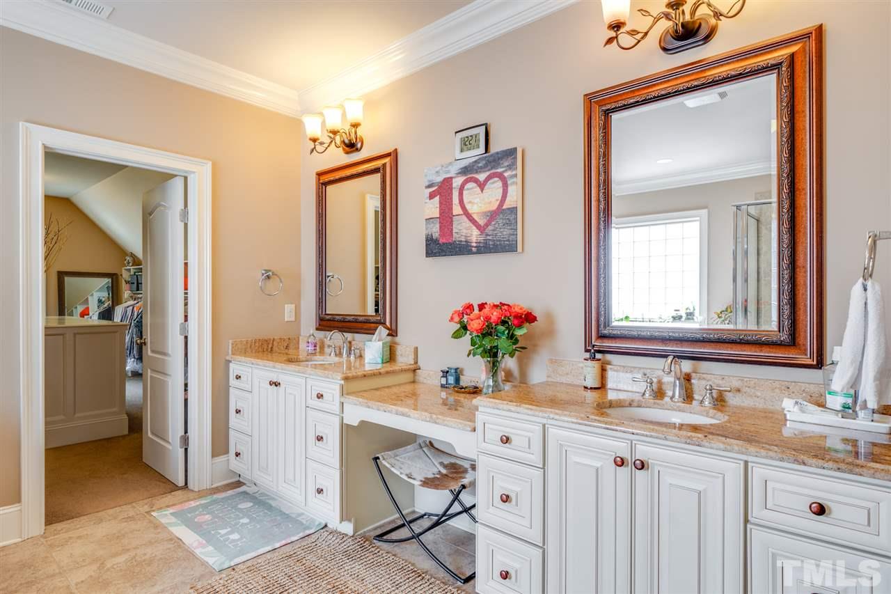 9020 Albatross Court Raleigh, NC 27613 - Photo 22 of 28 a bathroom with a sink vanity and a mirror