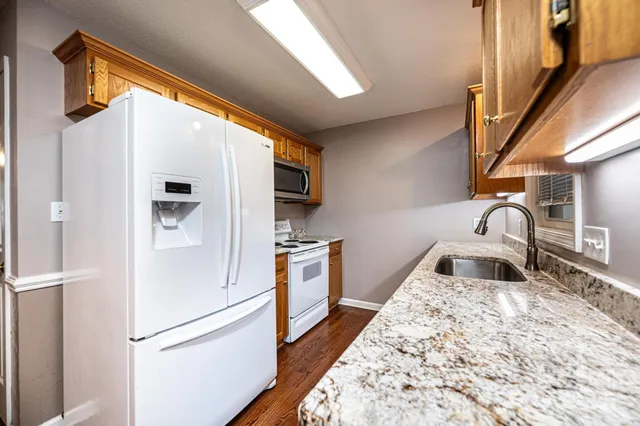 a kitchen with stainless steel appliances granite countertop a refrigerator and a sink