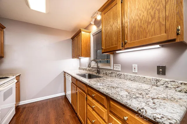 a kitchen with granite countertop sink and cabinets
