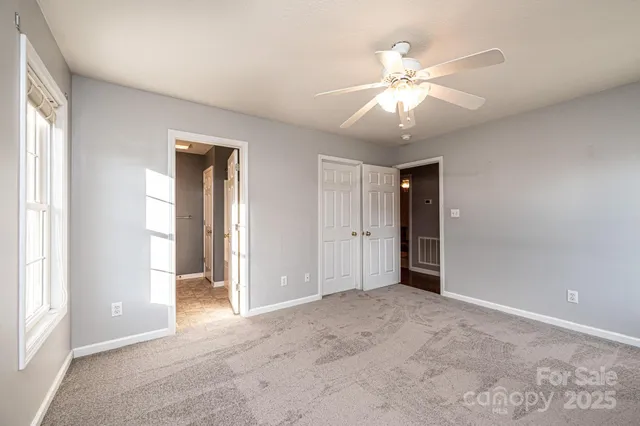 an empty room with fan and windows
