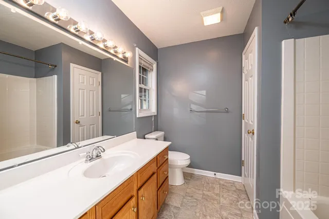 a bathroom with a double vanity sink mirror and toilet
