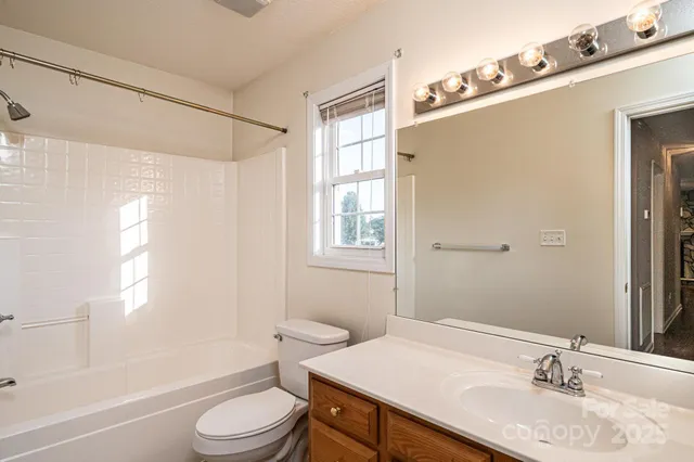 a bathroom with a granite countertop sink toilet a mirror and shower