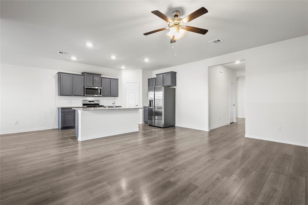 812 Indigo Road Princeton, TX 75407 - Photo 19 of 28 a view of kitchen with microwave refrigerator and cabinets
