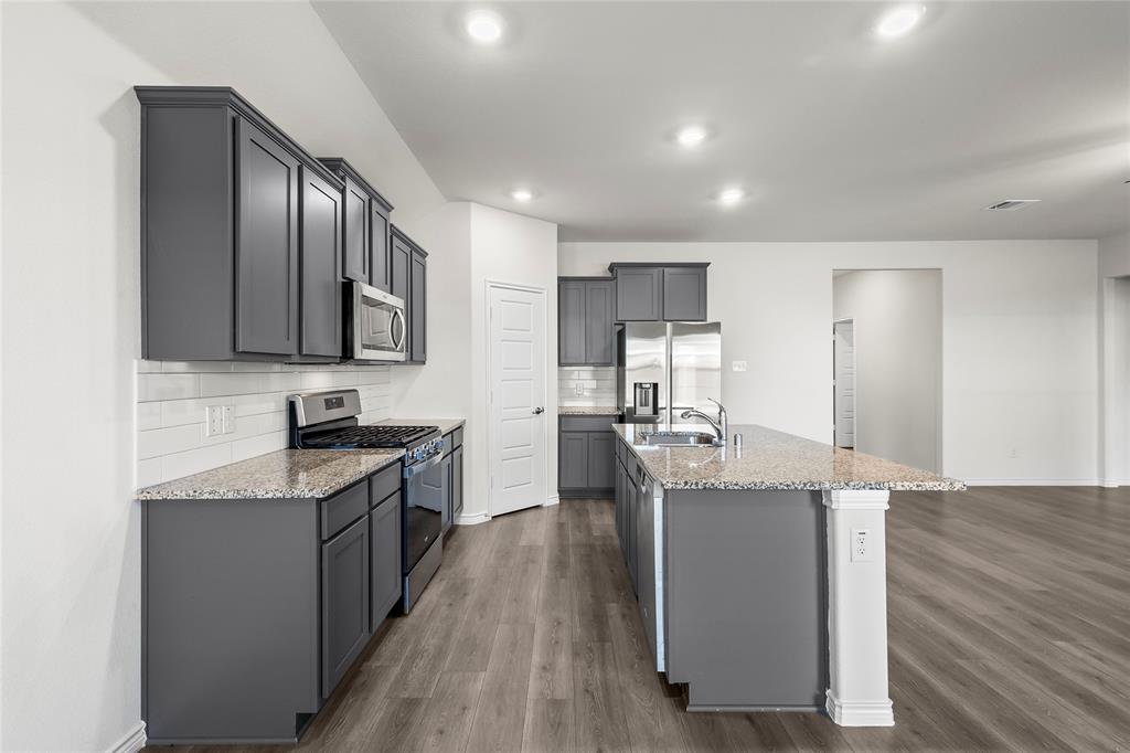 812 Indigo Road Princeton, TX 75407 - Photo 22 of 28 a kitchen with stainless steel appliances granite countertop a sink stove refrigerator and cabinets