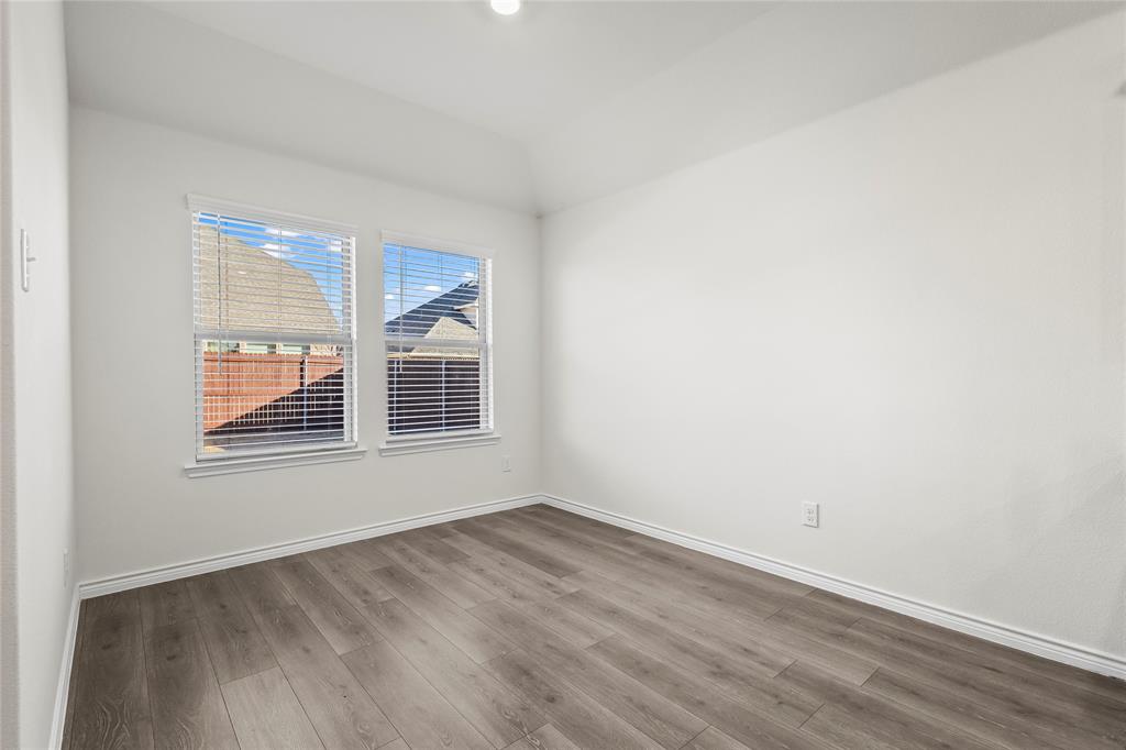 812 Indigo Road Princeton, TX 75407 - Photo 25 of 28 a view of an empty room with wooden floor and a window