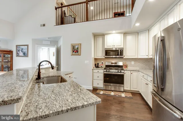 a kitchen with stainless steel appliances granite countertop a refrigerator and a stove top oven