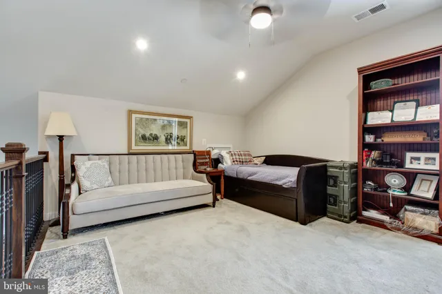 a living room with furniture and a book shelf