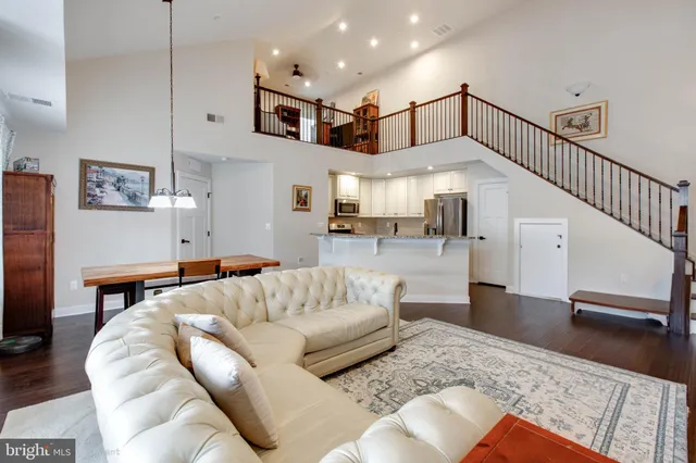 a living room with furniture and kitchen view with wooden floor