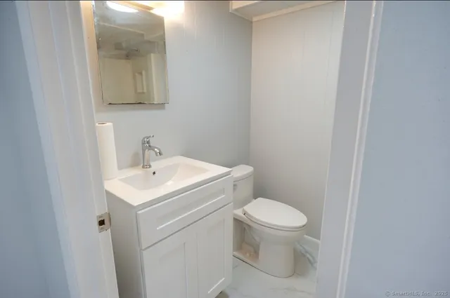 a bathroom with a toilet sink and mirror