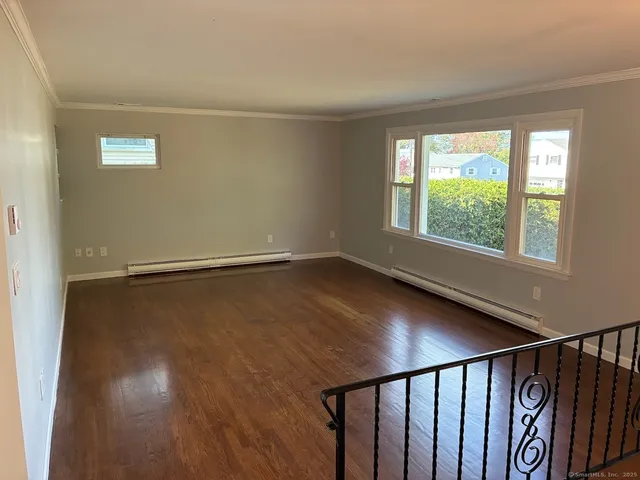 a view of a livingroom with wooden floor and a window