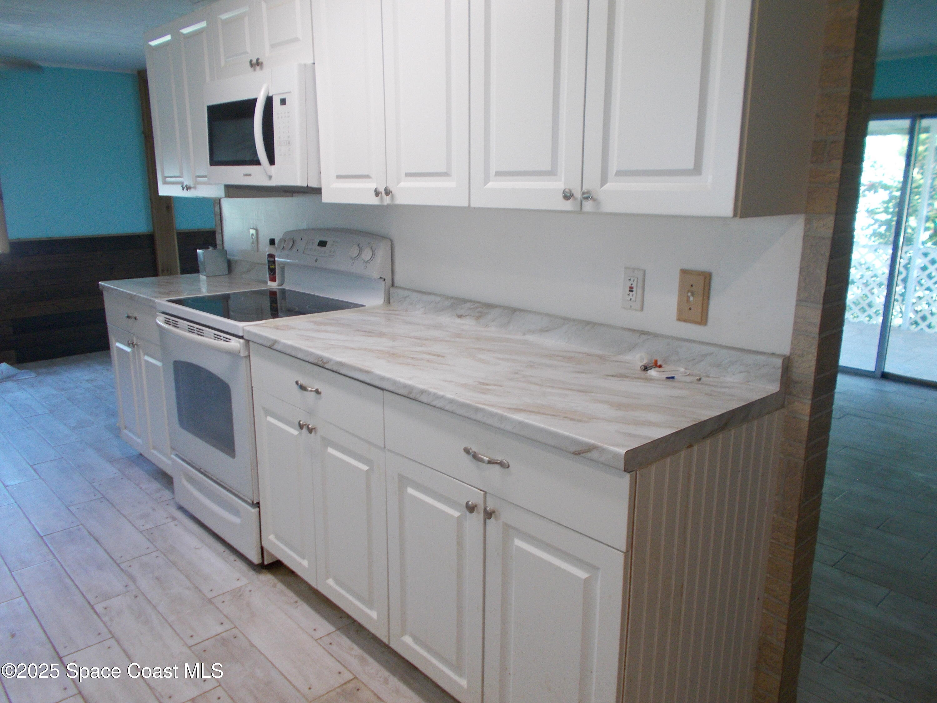 906 Spruce Street Sebastian, FL 32976 - Photo 5 of 26 a kitchen with stainless steel appliances granite countertop a sink dishwasher a stove and a microwave oven with white cabinets
