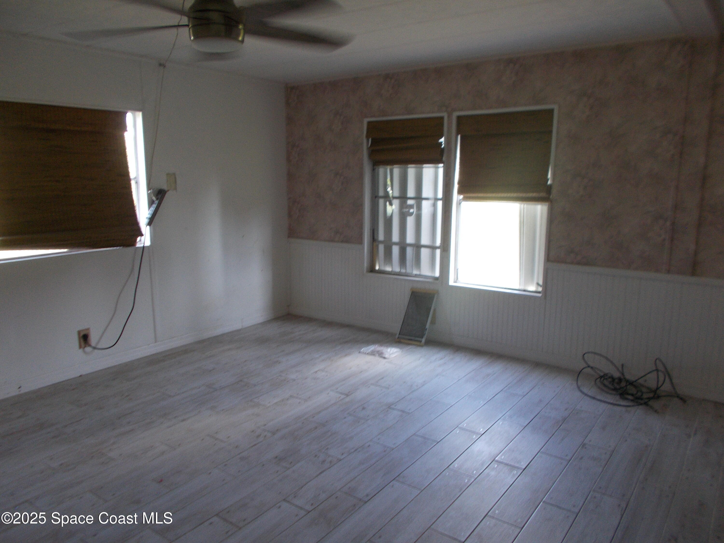 906 Spruce Street Sebastian, FL 32976 - Photo 9 of 26 an empty room with wooden floor and windows