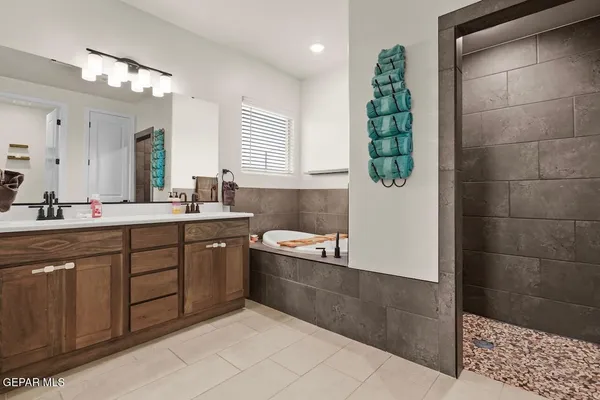 a spacious bathroom with a double vanity sink a mirror and a shower