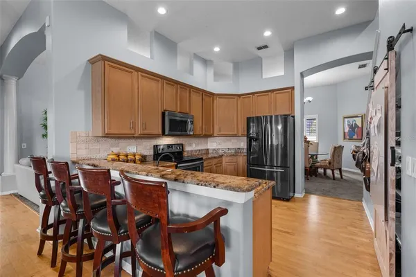 a kitchen with stainless steel appliances granite countertop a stove top oven a sink dishwasher and a refrigerator