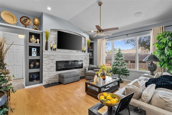 a living room with furniture a ceiling fan and a fireplace
