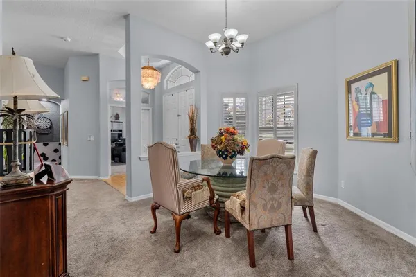 a dining room with furniture a chandelier and window
