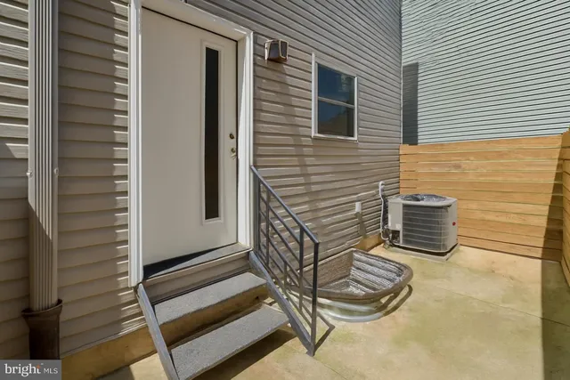 a view of an empty room with wooden stairs