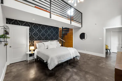 a spacious bedroom with a bed and a chandelier