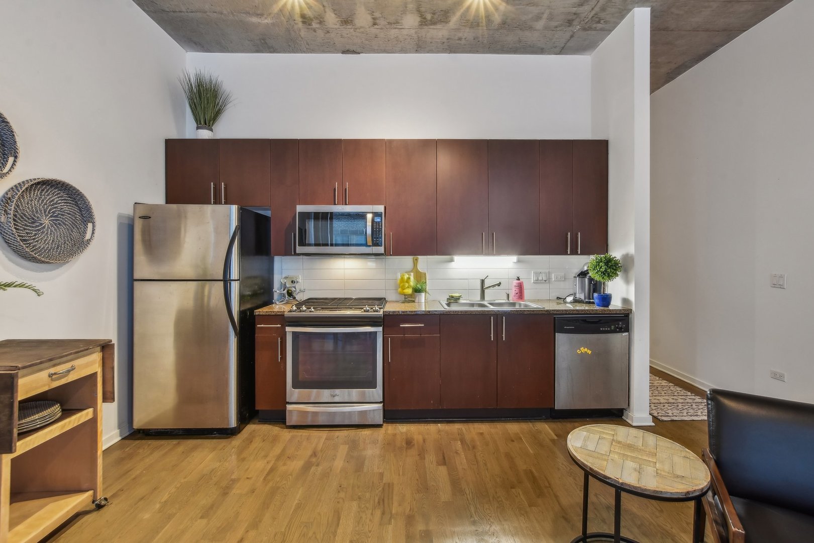 611 South Wells Street, Unit 702 Chicago, IL 60607 - Photo 11 of 32 a kitchen with stainless steel appliances granite countertop a refrigerator a stove a sink and a microwave