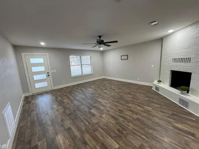 an empty room with a window and a fan