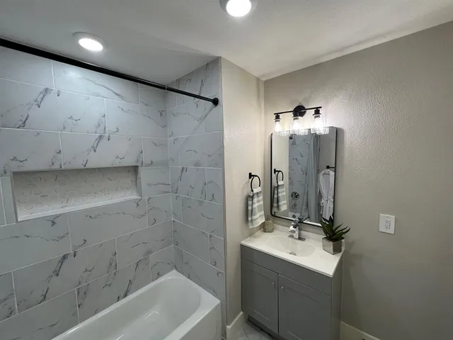 a kitchen with granite countertop a refrigerator stove and sink