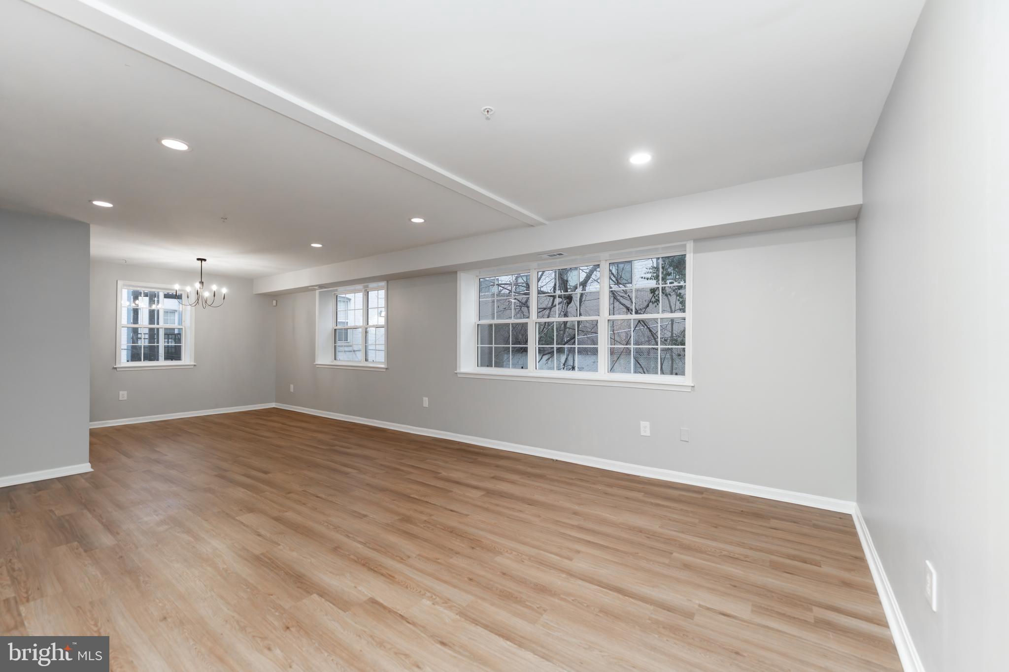 1008 Rittenhouse Street Northwest, Unit 15 Washington, DC 20011 - Photo 4 of 28 an empty room with wooden floor and windows