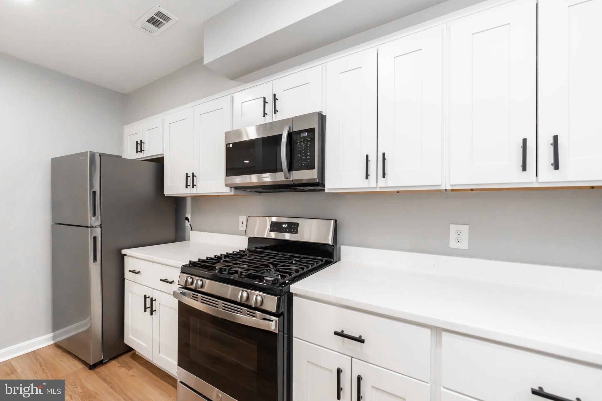 1008 Rittenhouse Street Northwest, Unit 15 Washington, DC 20011 - Photo 9 of 28 a kitchen with stainless steel appliances a stove microwave and refrigerator